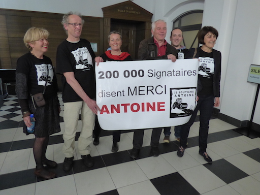 Members of the support commitee behind a sign: “200,000 signatories say THANKS to Antoine”