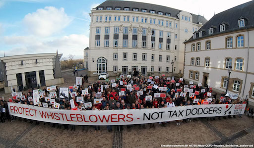 Les participants à la mobilisation, derrière une banderole “Protext whistleblowers, not tax dodgers”