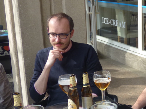 Antoine Deltour with a beer outside a café.