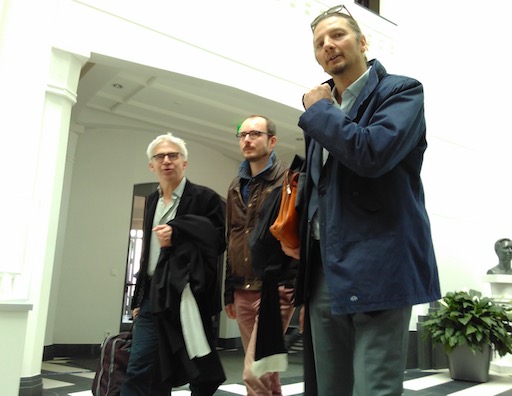 Antoine marche dans le hall du tribunal, Me Penning à sa gauche et Me Bourdon à sa droite”